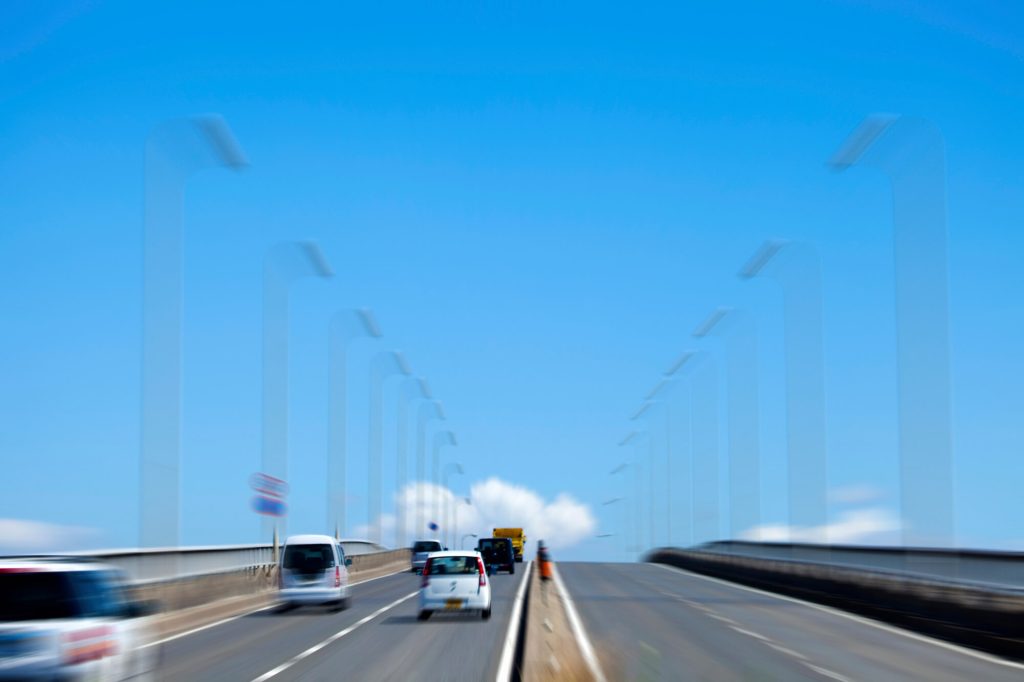 Cars driving on bridge under clear blue sky-img